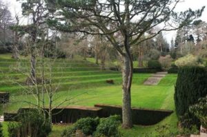 Dartington Hall Gardens. A well kept tiered lawn with shrubs and trees