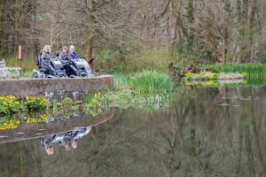 Three ladies in trampers overlooking the lake at RHS Rosemoor