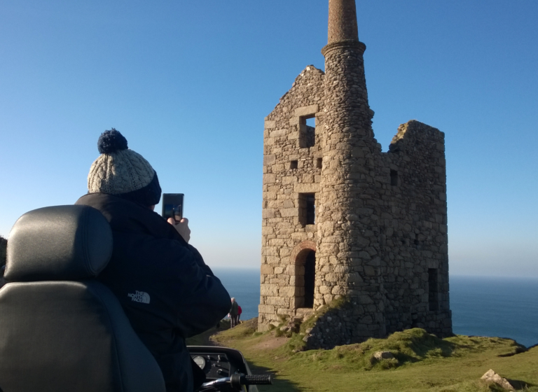 A man in a wooly hat on a Tramper taking a picture at Tin Coast