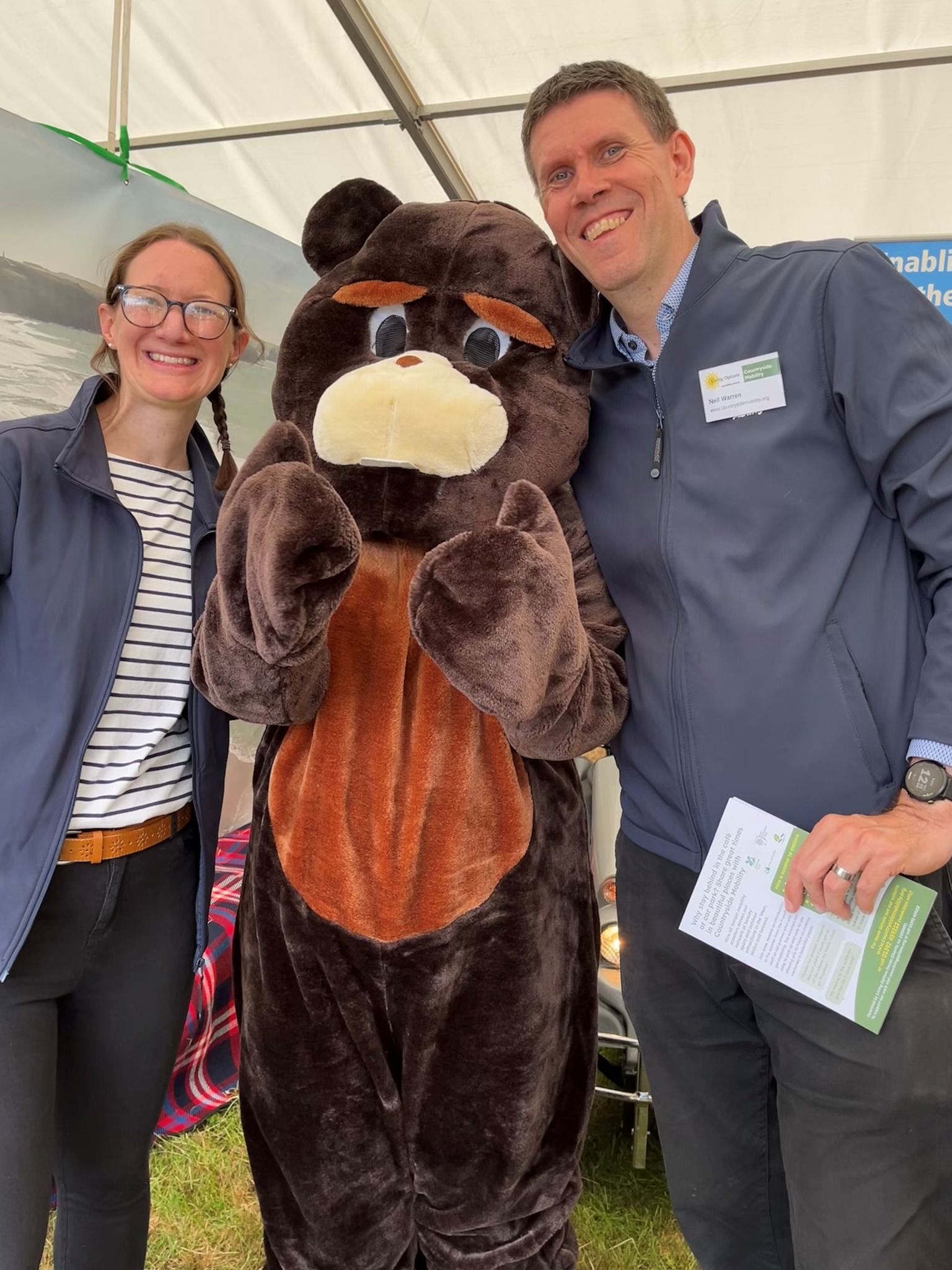 Neil and Emma stand next to a giant Beaver giving a thumbs up.