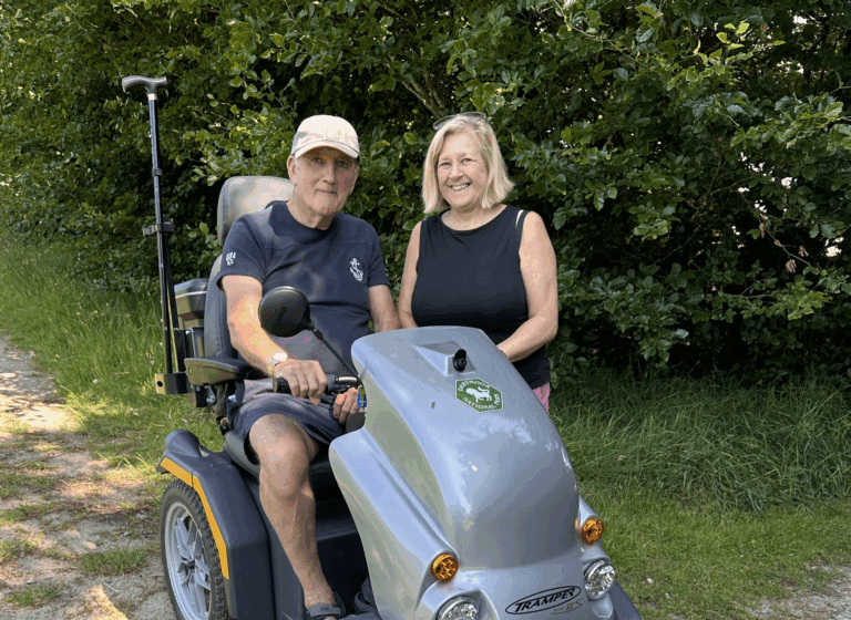 A woman stands next to a man on a Tramper. Both are smiling